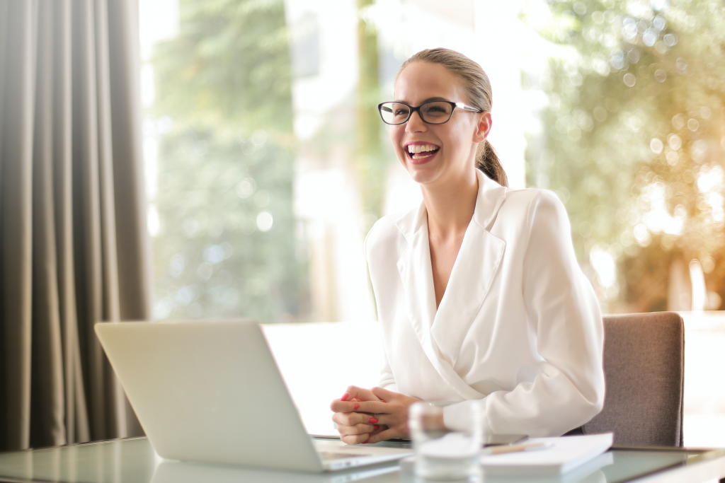 laughing-businesswoman-working-in-office-with-laptop-3756679